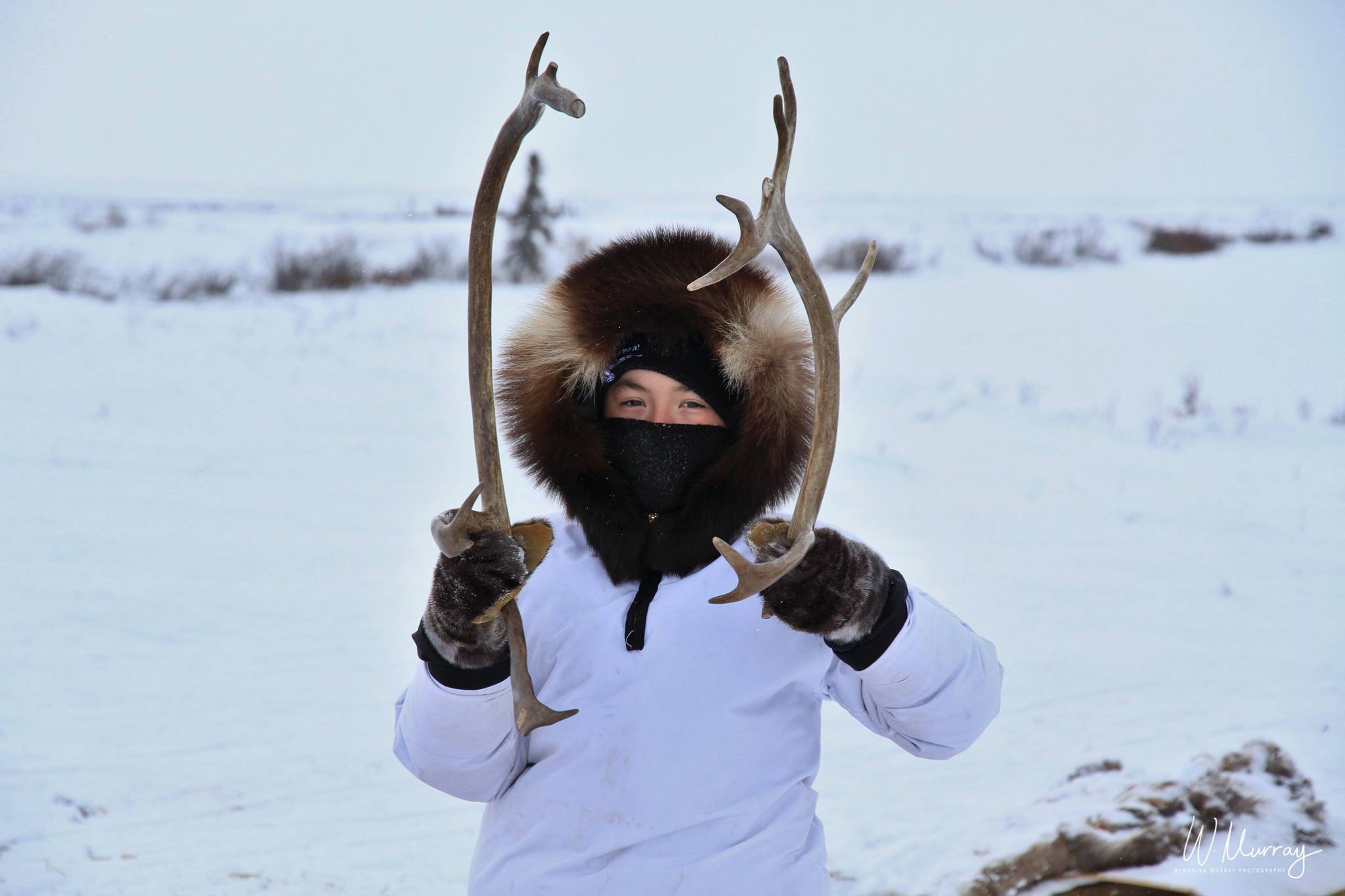 A young boy showing us the antlers of the caribou he hunted
