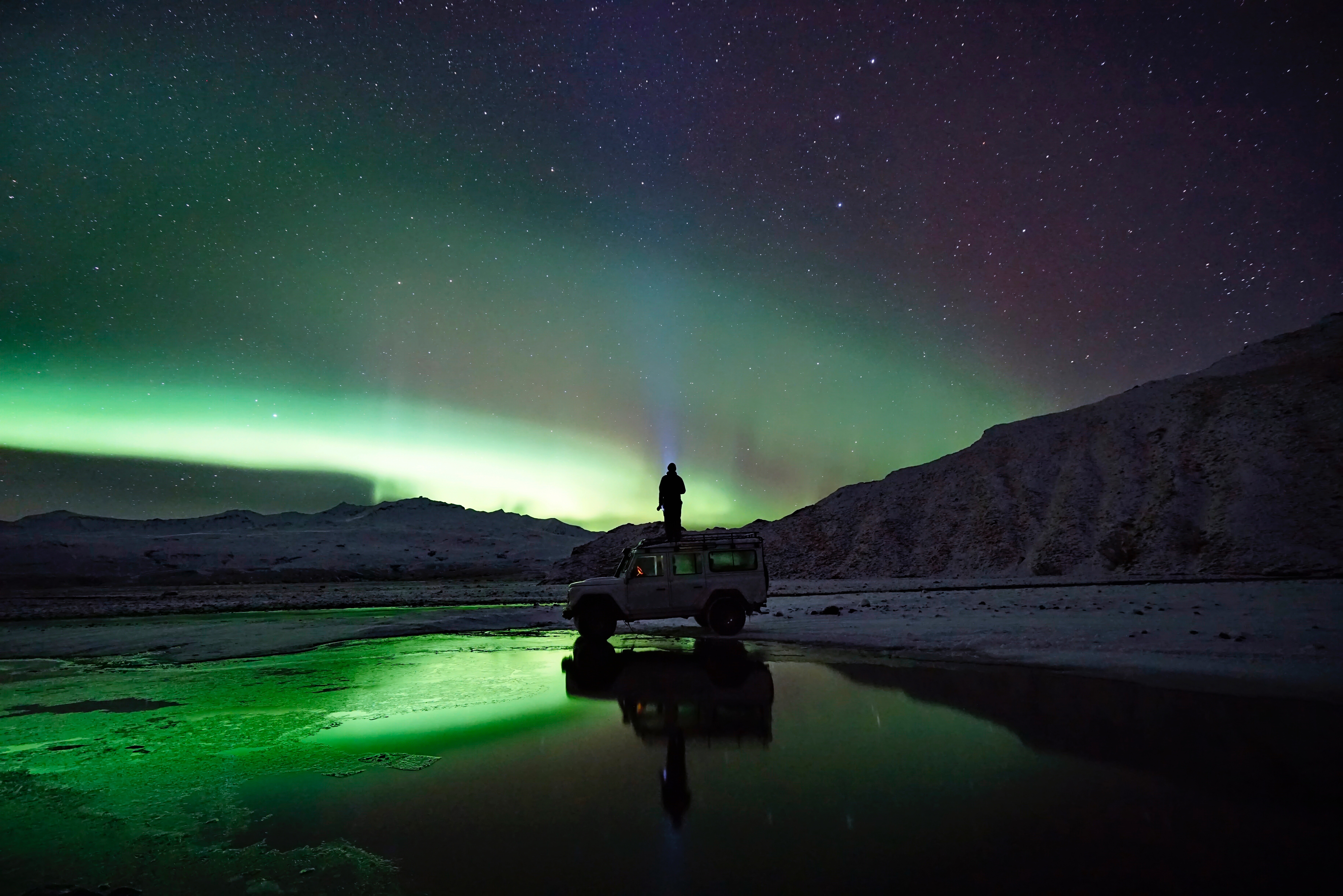 Man standing on his cheap underneath the beauty of the Aurora Borealis in the Northwest Territorries